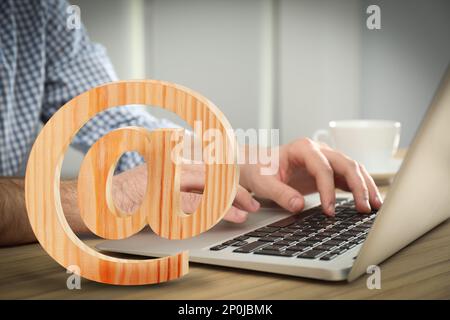 Sur l'illustration de l'affiche et l'homme envoyant un e-mail via l'ordinateur portable à la table, gros plan Banque D'Images