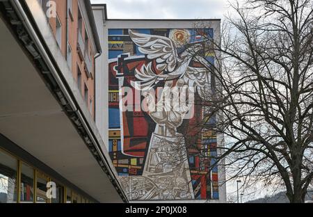 PRODUCTION - 14 février 2023, Brandebourg, Eisenhüttenstadt : une grande mosaïque d'œuvres de Walter Womacka (1925 - 2010) peut être vue sur une façade d'un ancien grand magasin. Eisenhüttenstadt est depuis des années la Mecque des visiteurs qui s'intéressent à l'architecture. Les trois premiers complexes résidentiels des 1950s et 1960s sont considérés comme l'un des plus grands monuments d'Allemagne. Ils sont également utilisés à maintes reprises comme un ensemble de films, et des visites guidées de la ville aux lieux de tournage sont en demande. Photo: Patrick Pleul/dpa Banque D'Images