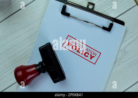 Concept d'estampille en caoutchouc à poignée rouge et texte de la politique d'annulation isolé sur une table en bois. Banque D'Images