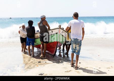 Des bateaux de pêche en bois colorés traditionnels tirés sur le rivage par des pêcheurs locaux sur une plage de sable dans le petit village de São Pedro, Cap-Vert. Banque D'Images