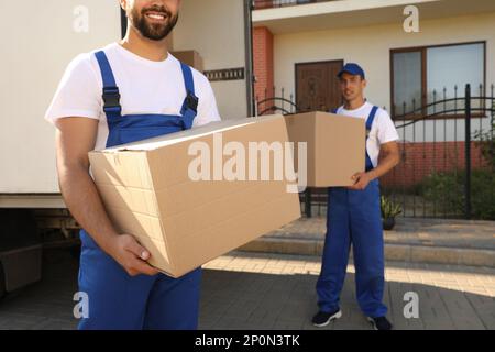 Les employés déchargent les caisses de la camionnette à l'extérieur. Service de déplacement Banque D'Images