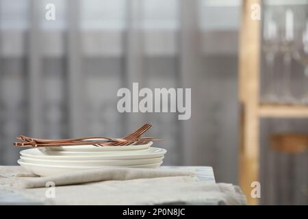 Empilez de la vaisselle propre, des couverts et des serviettes sur la table à l'intérieur Banque D'Images