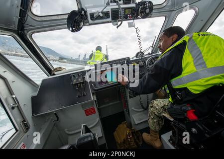 Master-at-Arms 2nd classe Keenan Martin effectue des manœuvres dans un bateau de sécurité portuaire pour disperser un objet flottant suspect lors d’un exercice d’entraînement antiterroriste à Commander Fleet Activities Sasebo (CFAS) dans le cadre de l’évaluation régionale de l’installation (SACR), le 15 février 2023. Le SACR fait partie du cycle d’entraînement et de certification du commandant, Marine installations Command (CNIC), de la Force de sécurité de la Marine, qui teste l’intervention et l’état de préparation de la force de sécurité d’une installation. Banque D'Images