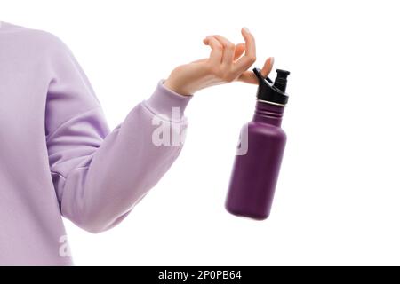 Coupe courte d'une femme dans un grand sweat-shirt de lavande tenant une bouteille violette réutilisable en acier inoxydable. Banque D'Images