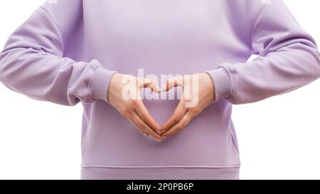 Une coupe courte d'une femme dans un grand sweat-shirt de lavande montre un signe de coeur. Concept de relation. Banque D'Images