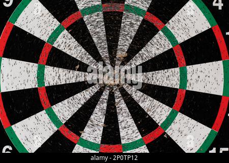 Vieux dartboard perforé par des fléchettes sur un mur léger. Arrière-plan d'une vieille cible ronde de merde dans les trous et les coupes pour le jeu de fléchettes symbole de précision et s. Banque D'Images