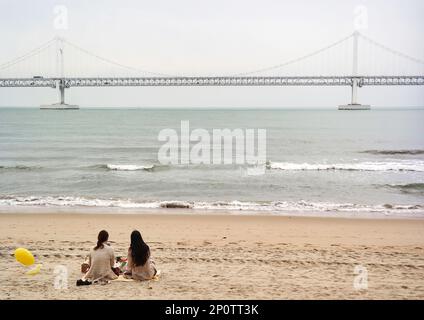 Busan, Corée du Sud - Mai 2019: Gwangandaegyo ou pont de diamant, pont suspendu photo prise de la plage de la ville de Busan dans une journée venteuse avec des vagues Banque D'Images