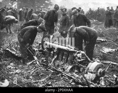 'Le Zeppelin Abattu; dans la banlieue Nord de Londres; inspection, par des ingénieurs et des hommes du Royal Flying corps, d'un des moteurs rebouve presque intact et a demi enfoul dans le sol', 1916. De "Collection de la guerre IV L'Illustration Tomé CXLVIII. La guerre Juillet, Aout, septembre, octobre, novembre, Décembre 1916". Banque D'Images