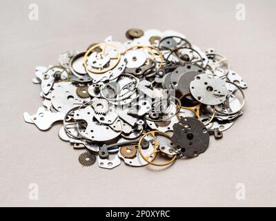 pile de différentes anciennes pièces de rechange pour montres mécaniques gros plan sur une table en bois dans l'atelier horloger Banque D'Images