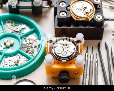 ouvrir les montres dans les supports et les outils sur la table en bois dans l'atelier horloger Banque D'Images