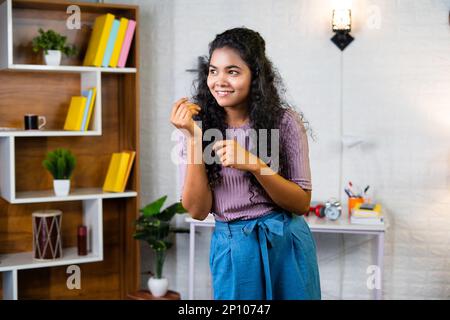 Bonne jeune femme souriante dansant sur la chanson préférée à la maison - concept de vacances de week-end, de divertissement et de liberté. Banque D'Images