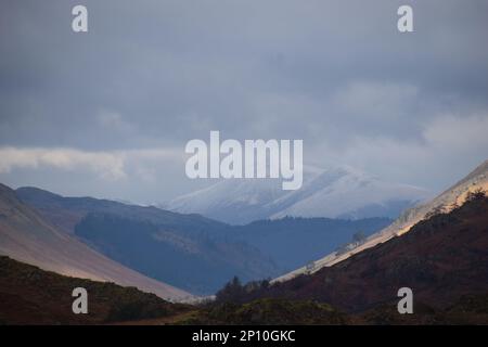 Un brochet de Scafell recouvert de neige dans la distance de brume vue de Todd Crag dans le district de English Lake. Banque D'Images