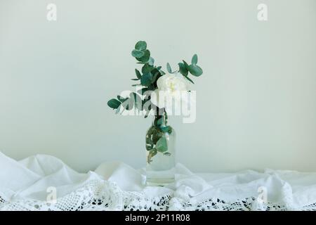 Fleur de pivoine blanche et eucalyptus dans une bouteille Banque D'Images