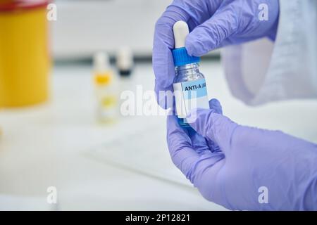 Réactif pour déterminer le type de sang dans les mains d'un employé de laboratoire Banque D'Images