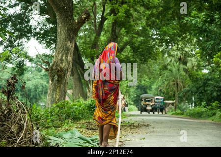 Photo d'une femme pauvre travaillant dans une rue à Faridpur, au Bangladesh. Banque D'Images