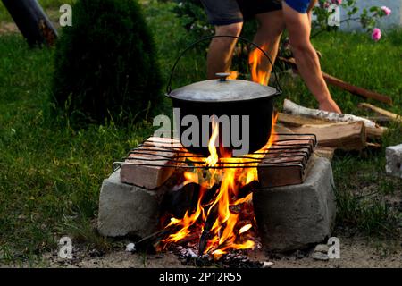 Recentrer la soupe de poisson dans le melon de fer sur un feu de camp. La soupe de poisson bout dans le chou-fleur au pieu. Soupe dans un pot dans le feu. Camp de jour. Ou Banque D'Images