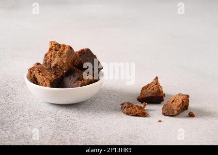 Kithul jaggery et sirop de mélasse sucré naturel dans un bol blanc sur fond gris. Copier l'espace. Gros plan. Sucre alternatif. Faible niveau de GI alimentaire. Super-nourriture . Banque D'Images