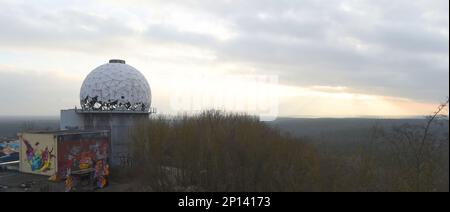 Berlin, Allemagne. 03rd mars 2023. Vu depuis le Teufelsberg de Berlin, le soleil se couche derrière l'horizon sous un ciel couvert et des températures froides. Sur la montagne se trouvent les bâtiments importants d'une station de contrôle et d'écoute de la circulation aérienne dont les bâtiments sont vides et délabrés et sont actuellement utilisés artistiquement. Credit: Felix Hörhager/dpa/Alay Live News Banque D'Images