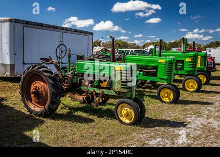 Fort Meade, FL - 24 février 2022: Vue d'angle avant grand angle d'un groupe de tracteurs John Deere lors d'une exposition locale des tracteurs. Banque D'Images