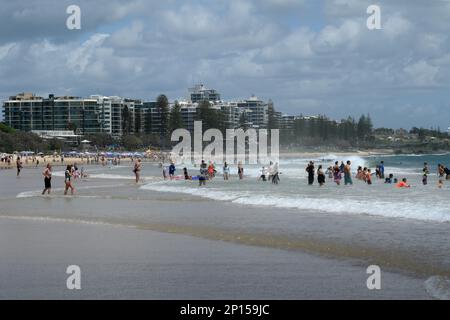 La plage de Mooloolaba. Les nageurs, les bodysurfeurs et les amateurs de soleil profitent des vagues de sable et de rivage avec des appartements en bord de mer Banque D'Images