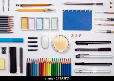 Composition de la papeterie sur fond blanc. Créateur, artiste, équipement sur un bureau blanc. Variété d'objets de bureau comme la peinture, le pinceau, le pe Banque D'Images