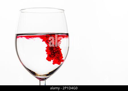 Liquide tourbillonnant rouge dans une tasse en verre transparent Banque D'Images