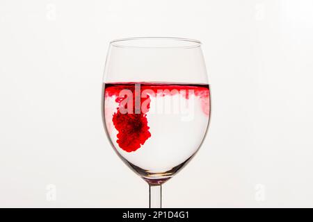 Liquide tourbillonnant rouge dans une tasse en verre transparent Banque D'Images