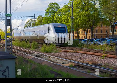 Vue sur le train électrique à vitesse de sortie passant le carrefour en ville. Uppsala. Suède. Europe. Banque D'Images