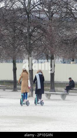 Paris, France. 19 février. 2023. Deux personnes en ville à cheval en libre-service location de scooters. Banque D'Images