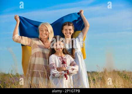 Famille heureuse avec drapeau national de l'Ukraine sur le terrain Banque D'Images