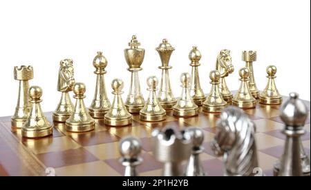 Jeu de pièces d'échecs dorées sur un panneau en bois sur fond blanc Banque D'Images