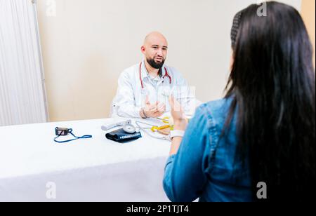 Vue arrière d'une patiente parlant à la nutritionniste. Nutritionniste souriant expliquant à une patiente, nutritionniste homme parlant à la femme Banque D'Images