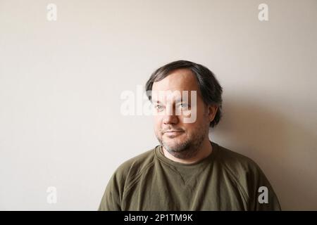 Vrai homme authentique dans la quarantaine contre mur intérieur avec copie espace et lumière naturelle Banque D'Images