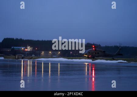 BASE CONJOINTE ELMENDORF-RICHARDSON, Alaska -- portant U.S. Les gardes-côtes de l'équipe d'intervention de la sécurité maritime, un hélicoptère de recherche et de sauvetage HH-60G du 210th Escadron de sauvetage Pave Hawk, effectuent un entraînement de levage conjoint le 23 janvier 2023 à la station de la Garde côtière Kodiak. La formation interagences comprenait la participation des États-Unis Guerre spéciale navale, équipe d'intervention de la Garde côtière en matière de sécurité maritime et Escadron de sauvetage 210th de la Garde aérienne nationale de l'Alaska. Banque D'Images