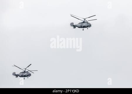 Deux hélicoptères militaires russes Kamov Ka-27 volent dans un ciel nuageux pendant la journée Banque D'Images