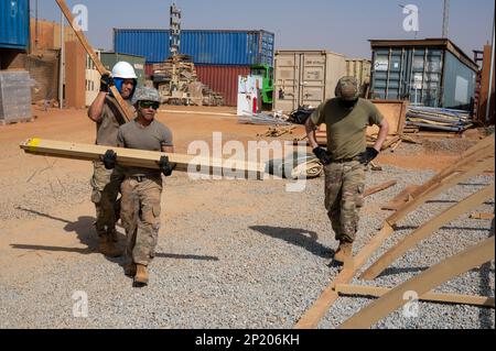 ÉTATS-UNIS Des aviateurs de l'escadron 768th de la base aérienne expéditionnaire, vol du génie civil, transportent des sections de tente pendant la construction à l'AB 101, Niger, le 6 février 2023. La taille de la tente construite par les aviateurs ce, peut être construite et couverte en une seule journée, ce qui permet de créer une structure utilisable en peu de temps. Banque D'Images