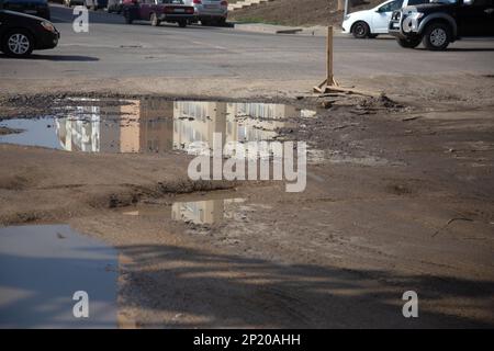 En raison de la violation de la technologie de construction routière, de fortes gelées et de fortes pluies, l'asphalte a lavé la route et de nombreuses fissures se sont formées Banque D'Images