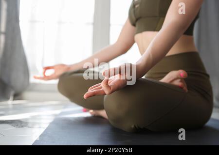 Yogini fille faisant de l'exercice de méditation le matin. Une jeune femme méconnaissable assise dans le lotus pose une méditation. Banque D'Images