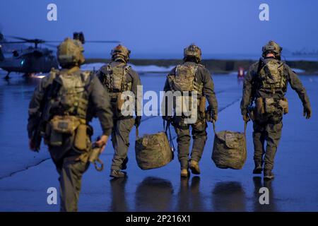 BASE COMMUNE ELMENDORF-RICHARDSON, ALASKA -- ÉTATS-UNIS Les gardes-côtes de l'équipe d'intervention de la sécurité maritime embarquent à bord d'un hélicoptère de recherche et de sauvetage HH-60G du 210th Escadron de sauvetage Pave Hawk pour l'entraînement de levage le 23 janvier 2023, à la station de la Garde côtière Kodiak. La formation interagences comprenait la participation des États-Unis Guerre spéciale navale, équipe d'intervention de la Garde côtière en matière de sécurité maritime et Escadron de sauvetage 210th de la Garde aérienne nationale de l'Alaska. Banque D'Images