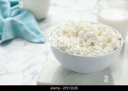 Délicieux fromage cottage frais dans un bol sur une table en marbre blanc Banque D'Images