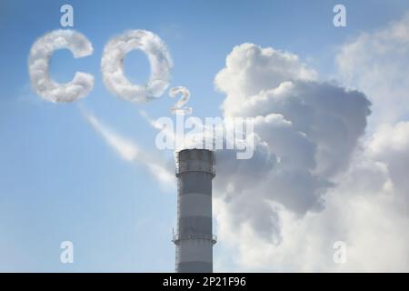 Inscription CO2 faite de fumée. Pollution de l'air provenant de cheminées industrielles à l'extérieur contre le ciel bleu Banque D'Images