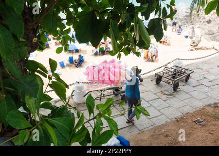 Salvador, Bahia, Brésil - 14 janvier 2022: Un marchand de bonbons en coton marche le long des trottoirs de la plage de Porto da Barra à Salvador, Bahia. Banque D'Images