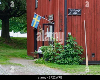 Nykoping, Suède - 28 août 2019: Maisons en bois rouge au bord de la rivière Nyköpingsån dans la petite ville du Sud de la Suède. Nyköping, Europe du Nord Banque D'Images