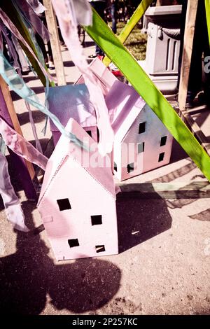 Petites maisons en carton et rubans décorations pour une fête de célébration. Petits bâtiments en carton violet dans un village de conte de fées coloré Banque D'Images