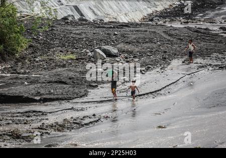 Les enfants philippins aident les parents à nettoyer le lit du cours d'eau de la rivière surexploités avec des cendres de l'éruption du volcan Mayon pour éviter le flux de cendres de lahar, Philippines Banque D'Images