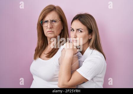 Mère hispanique et fille portant décontracté t-shirt blanc sceptique et nerveux, frowning bouleversé à cause du problème. Personne négative. Banque D'Images