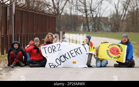 Landshut, Allemagne. 04th mars 2023. Les activistes de l'initiative 'Runterfahren' manifestent devant la centrale nucléaire Isar 2 près de Landshut avec une bannière lisant 'Tor 2 blogiert!'. Les militants voulaient protester contre une éventuelle prolongation de la durée de vie des centrales nucléaires allemandes en bloquant la voie d'accès. Crédit : Lukas Barth/dpa/Alamy Live News Banque D'Images