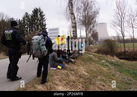 Landshut, Allemagne. 04th mars 2023. Les militants de l'initiative 'Runterfahren' sont empêchés par la police de bloquer les routes d'accès à la centrale nucléaire Isar 2 près de Landshut. Les militants veulent protester contre une éventuelle prolongation de la durée de vie des centrales nucléaires allemandes. Crédit : Lukas Barth/dpa/Alamy Live News Banque D'Images