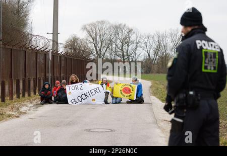 Landshut, Allemagne. 04th mars 2023. Les activistes de l'initiative 'Runterfahren' manifestent devant la centrale nucléaire Isar 2 près de Landshut avec une bannière lisant 'Tor 2 blogiert!'. Les militants voulaient protester contre une éventuelle prolongation de la durée de vie des centrales nucléaires allemandes en bloquant la voie d'accès. Crédit : Lukas Barth/dpa/Alamy Live News Banque D'Images