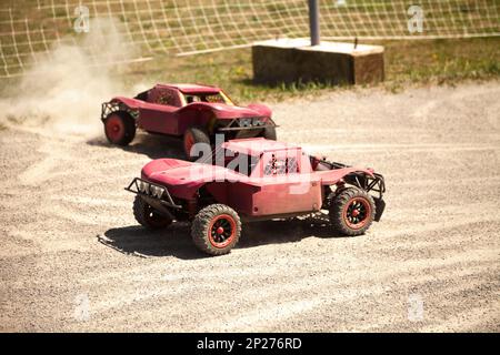 Deux petites voitures modèle radio-commandé racing dans la poussière. Buggy télécommandé miniature racing hobby Banque D'Images